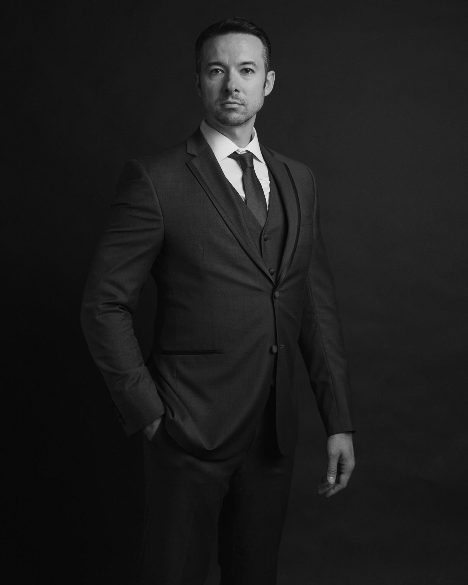 Black and white standing portrait of a man in a suit