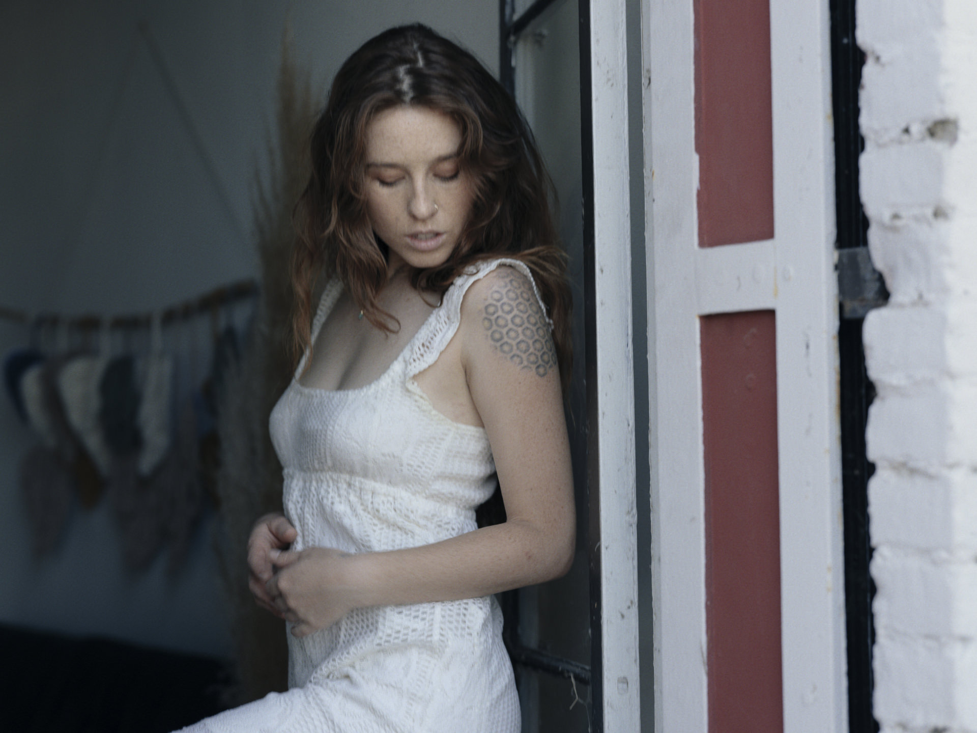 Kisa standing in white against the doorway