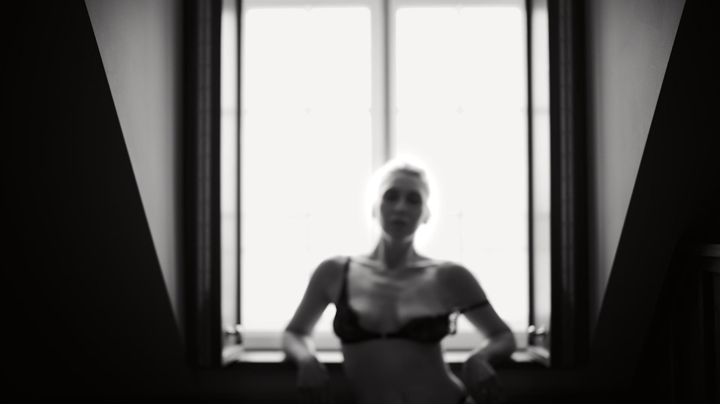 Melinda reclining in color against a dark interior
