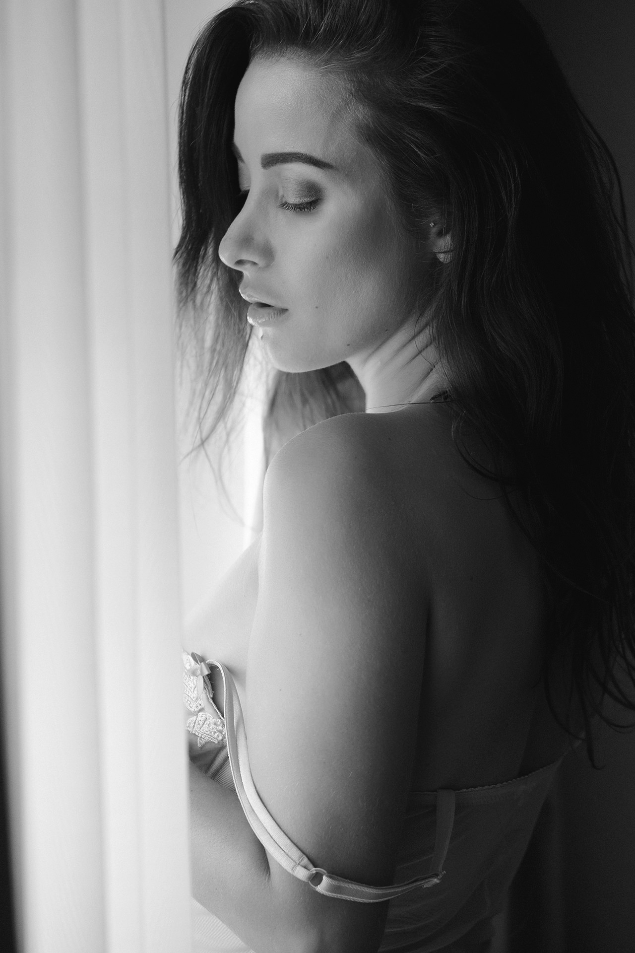 Vertical black and white portrait in soft interior light
